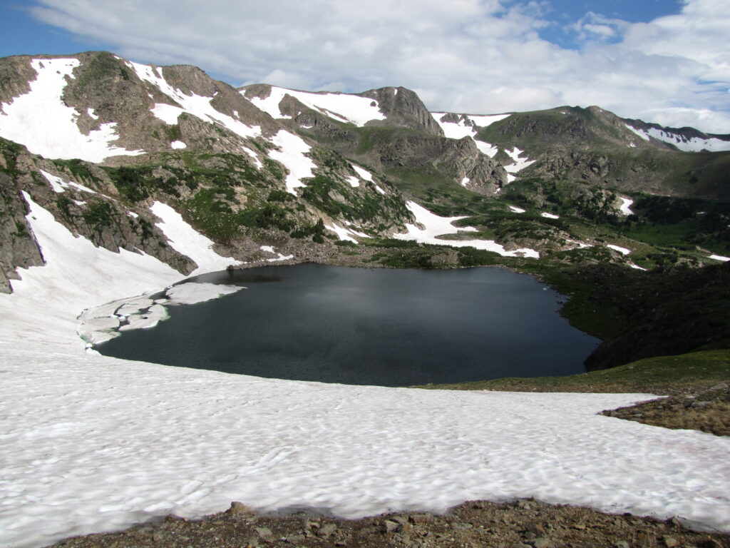 snowy mountains surrounding an alpine lake